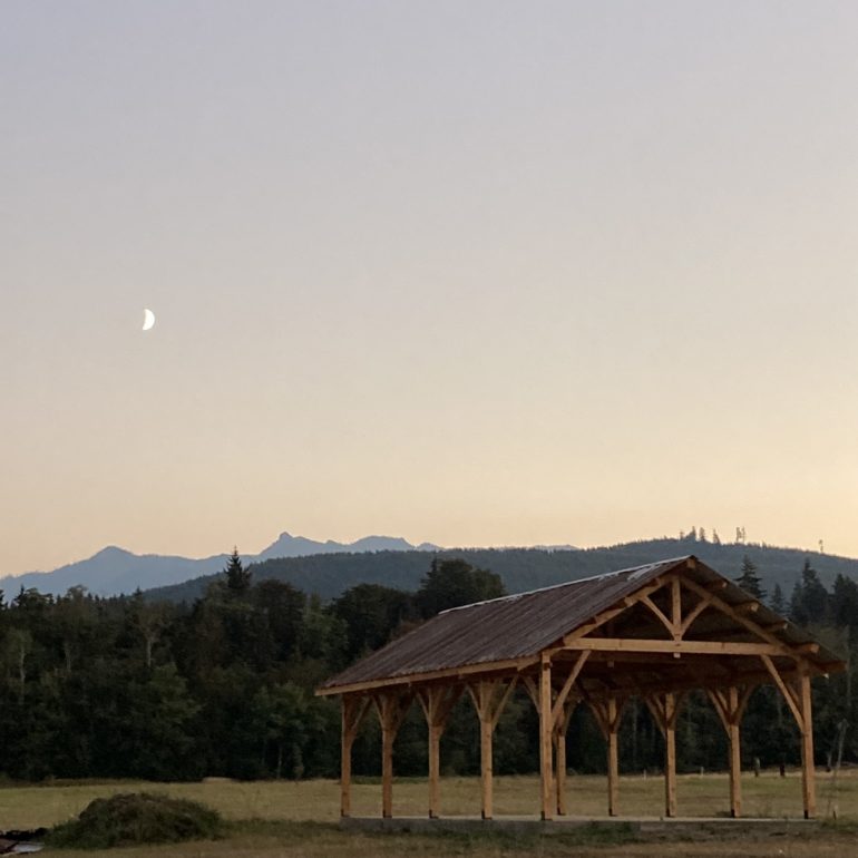 Moon over the Olympic Ranges and timber frame structure at Olympic outpost